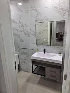 ein Badezimmer mit einem weißen Waschbecken und einem Spiegel in der Unterkunft Areias de Bombas in Bombinhas