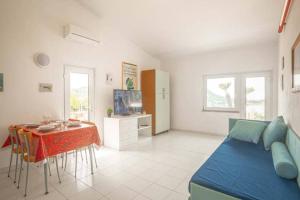 - un salon avec un canapé bleu et une table dans l'établissement Giglio Verde 2, à Isola del Giglio
