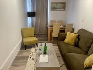een woonkamer met een bank, stoelen en een tafel bij Le MONOT Residence in Bazel