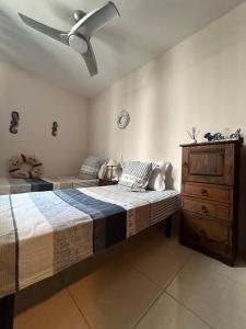 1 dormitorio con 2 camas y ventilador de techo en Casa Gloria, en Los Abrigos