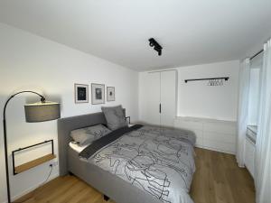 1 dormitorio con 1 cama en una habitación blanca en Coucou - Nest im Schwarzwald, en Gengenbach