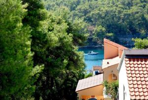 a boat in the water next to a building at Guest House Alek in Vrboska