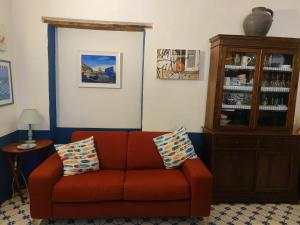 ミノーリにあるCasabluette a Minori - Amalfi coastのリビングルーム(赤いソファ、キャビネット付)