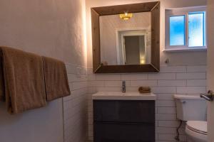 a bathroom with a sink and a mirror and a toilet at NEW! Chic & Cozy Lantana near the Beach & Flagler in New Smyrna Beach