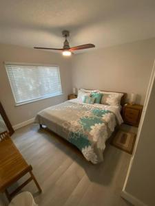 um quarto com uma cama e uma ventoinha de tecto em NEW! Chic & Cozy Lantana near the Beach & Flagler em New Smyrna Beach