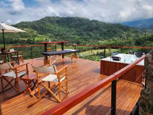 una terraza de madera con sillas, mesa y fregadero en El eden hotel Boutique, en Sasaima