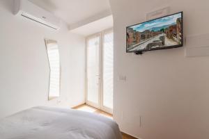 a bedroom with a flat screen tv on the wall at Villarena Relais in Nerano