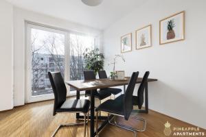 een eetkamer met een tafel en stoelen en een raam bij Pineapple Apartments Dresden Zwinger VIII - 85 qm - 1x free parking in Dresden