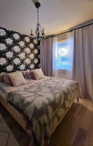a bedroom with a bed with a floral headboard and a window at Arctic Circle Home in Rovaniemi
