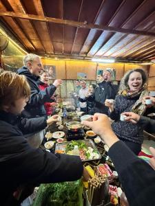 een groep mensen die rond een tafel met eten staan bij Bao Lac Homestay Hostel & Coffee in Bảo Lạc