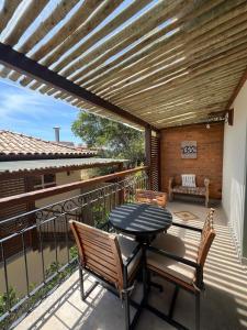 um pátio com uma mesa e cadeiras numa varanda em Pousada Villa Canaã em Búzios