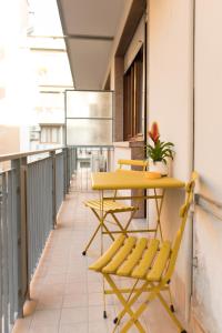 a yellow table and chairs on a balcony at L'Attimo Guesthouse in Verona +20 photos