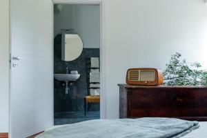 a bathroom with a bed and a sink and a mirror at Villa Orta - Agriturismo con colazione Vegan, Plant-based Farmhouse in Riotorto
