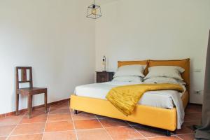 a bedroom with a bed with a yellow blanket on it at Villa Orta - Agriturismo con colazione Vegan, Plant-based Farmhouse in Riotorto