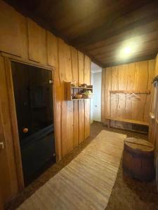 um quarto com paredes com painéis de madeira e uma grande televisão em Vecvanagi em Jaunmuiža
