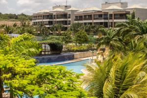 Cumbuco Wai Wai Apartamento com vista para o mar في كومبوكو: منتجع فيه مسبح امام مبنى