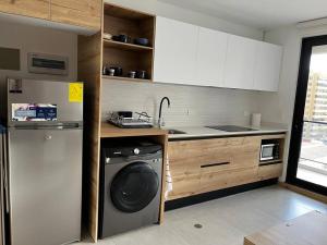 een keuken met een wasmachine bij Estudio luminoso con balcón in Quito