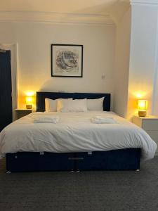 a bedroom with a large bed with two lamps on both sides at Abbie Lodge Guest House in Weston-super-Mare