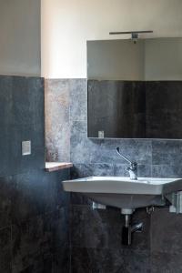 ein Bad mit einem Waschbecken und einem Spiegel in der Unterkunft Villa Orta - Agriturismo con cucina Vegan, Plant-based Farmhouse in Riotorto