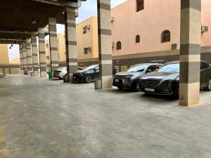 un grupo de autos estacionados en un estacionamiento en Al-Aniqa Furnished Apartments en Riad