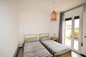 1 dormitorio con 1 cama y ventana con balcón en Magica Immobiliare - Villa Mimosa 11, en Lido di Jesolo