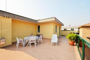 patio con mesa y sillas en el balcón en Magica Immobiliare - Villa Mimosa 11, en Lido di Jesolo