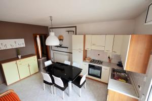 cocina con armarios blancos, mesa y sillas en Magica Immobiliare - Villa Mimosa 11, en Lido di Jesolo
