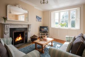 HolbetonにあるHarlequin Houseの暖炉とテーブルのあるリビングルーム