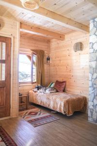Bett in einem Zimmer mit einer Holzwand in der Unterkunft Koliba Vuk in Sekulić 