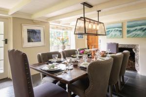 a dining room with a wooden table and chairs at Huckleberry Cottage in Hope Cove