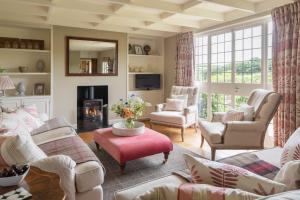 a living room with couches and chairs and a fireplace at Huckleberry Cottage in Hope-Cove