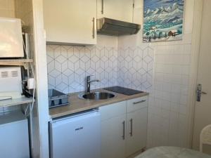 małą kuchnię ze zlewem i białymi szafkami w obiekcie Studio Centre-Ville avec Terrasse, Équipé, Lumineux - FR-1-703-8 w mieście Amélie-les-Bains-Palalda