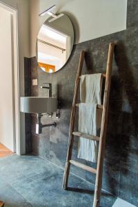 ein Badezimmer mit einer Leiter neben einem Waschbecken und einem Spiegel in der Unterkunft Villa Orta - Agriturismo con cucina Vegan, Plant-based Farmhouse in Riotorto