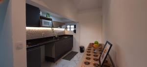 uma pequena cozinha com um lavatório e um micro-ondas em Apartamento Mania Terceiro Andar em Vitória