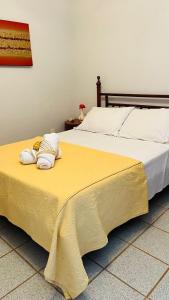 een groot bed met een gele deken erop bij Suites Casa Maia in Capitólio