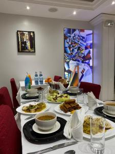 einen langen Tisch mit Teller mit Lebensmitteln drauf in der Unterkunft Hôtel des beaux-arts in Alger
