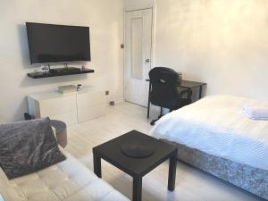 a small living room with a bed and a tv at Spacious modern family bedroom in Central London in London