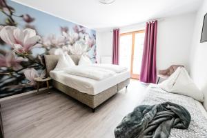 a bedroom with two beds and a flower mural at Appartements Flor in Wasserhofen