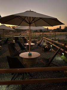 un tavolo e sedie con ombrellone in un campo di Nenquen Lodge a Santa Cruz