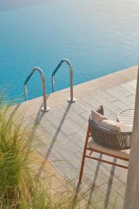 a chair sitting on a patio next to the water at True Beach Resort in Marsa Alam City