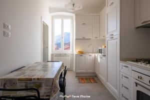 a white kitchen with a table and a window at BlueGreen in La Spezia