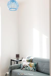 a living room with a blue couch and a lamp at BlueGreen in La Spezia +7 photos