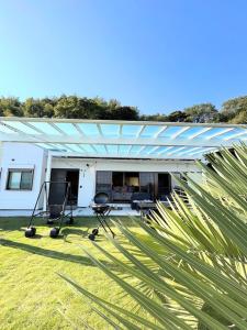 a white house with a pergola on the grass at Shell Beach Hamanako - Vacation STAY 14730 in Hamamatsu