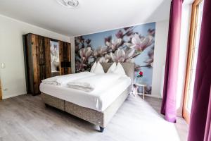 a bedroom with a bed with a floral wall at Appartements Flor in Wasserhofen