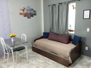 a small bedroom with a bed and a table at Flat Solife 2 Cabo Frio-Búzios in Cabo Frio