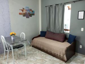 a small room with a bed and a table at Flat Solife 2 Cabo Frio-Búzios in Cabo Frio