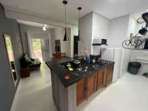 a kitchen with a black counter top and a refrigerator at Villagio Valentina in São Sebastião