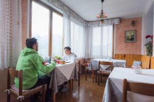 two people sitting at a table in a restaurant at Hotel El Paso in Fai della Paganella