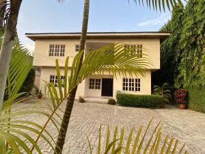 a house with a palm tree in front of it at ChallawaRiver Homes in Calabar