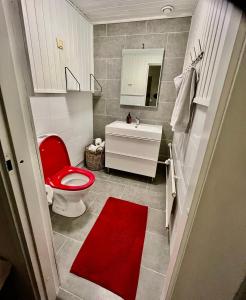 baño con aseo rojo y lavamanos en Nice and cozy townhouse, en Rovaniemi